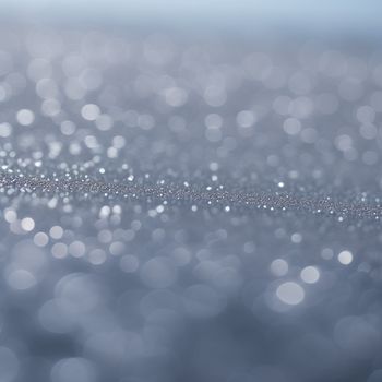 blurry photo of a silver surface with small bubbles of water on it and a blurry background