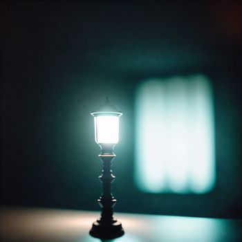 small light is lit up on a table in the dark room with a blurry background of a window