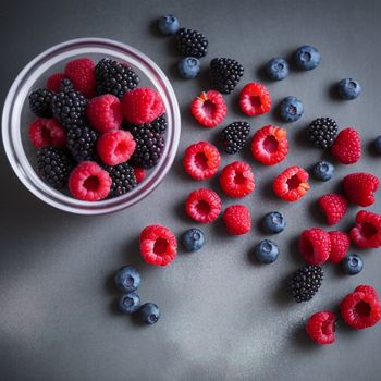 bowl of berries and raspberries on a table with a bowl of berries and raspberries