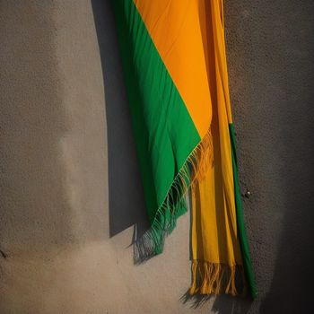 yellow and green scarf laying on a beach next to the ocean and sand on the beach