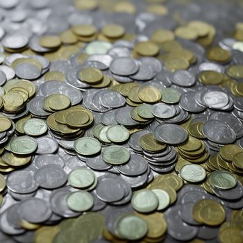 pile of coins sitting on top of a table next to each other on a table top with a black background