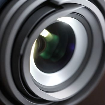 close up of a camera lens with a blurry background of the lens and the lens itself is visible