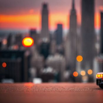 toy car is parked in front of a cityscape at sunset