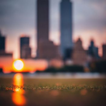 blurry photo of a city skyline with the sun in the background