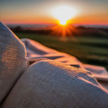 the sun is setting in the distance behind a pillow on a bed