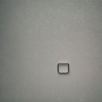 square shaped object on a wall with a white wall in the background