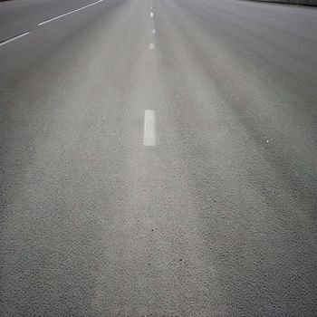 an empty highway with white lines on the side of the road and trees on the other side of the road